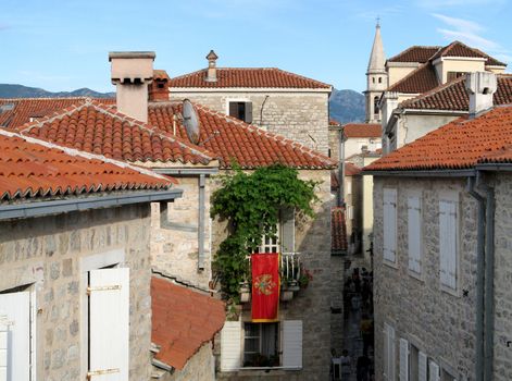 Medieval town Budva in Montenegro, view from town wall, with montenegro flag