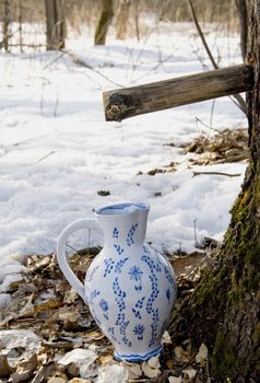 Birch sap drops in white ornamental ceramic pitcher