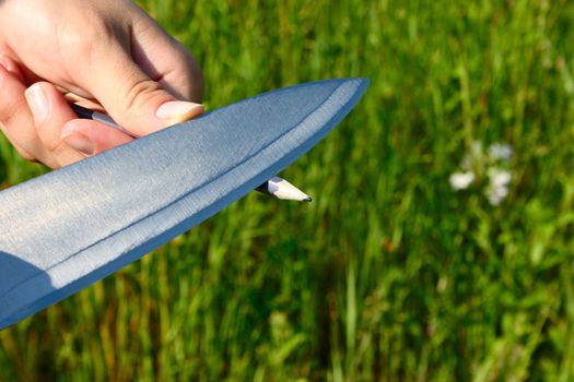 Sharpening of a pencil by a knife in marching conditions