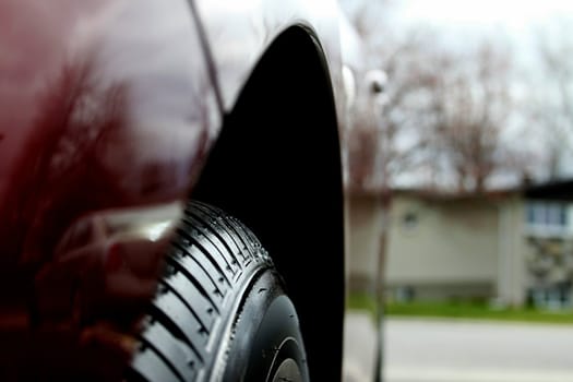 A close up look of the front wheel of red car