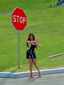 Playful image of girl near a traffic sign, symbolizing her inaccessibility and shyness.