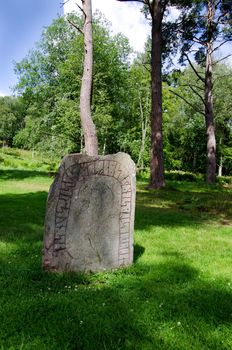 An ancient rune stone, strange rune letters, a summer day in Sweden.