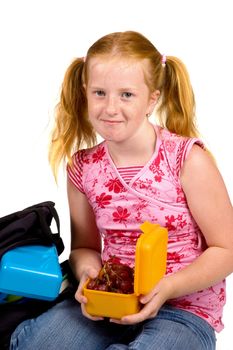 schoolgirl is having grapes as lunch isolated on white