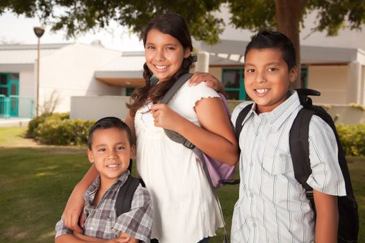 Cute Brothers and Sister Wearing Backpacks Ready for School.