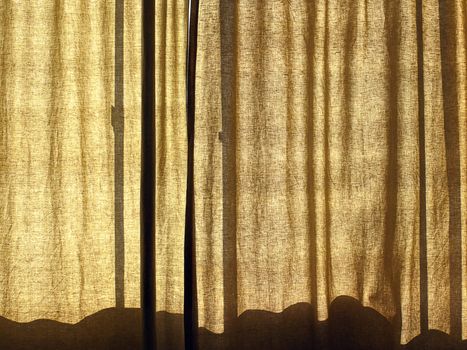 Bedroom curtains filtering summer morning sunlight.