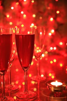Champagne in glasses on red background with twinkle lights