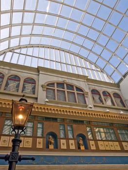 A street lamp inside a shopping center under a blue summer sky.