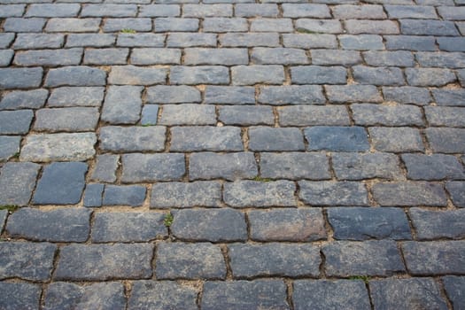 Old stone-paved road, front-focused.  Stone surface