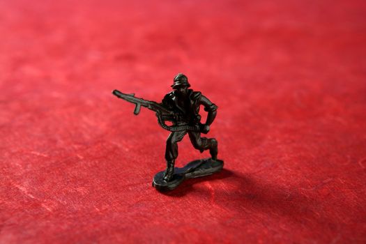 Plastic toy soldier over red background, war metaphor
