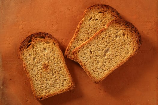 Toasted bread slices over orange clay background