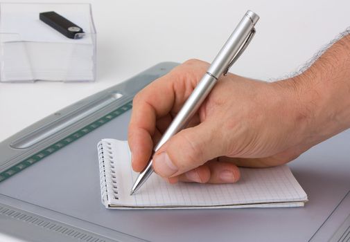 Write with a ballpoint pen in a notebook