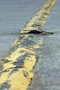 Traveling the length of a yellow speed bump, which has not been properly maintained.