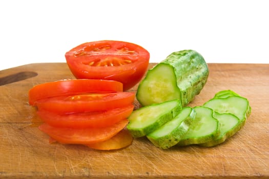 cucumber and tomato slices on a cutting board isolated on a white background