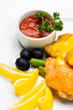 Fish with mayonnaise, served with asparagus, olives, lemon and tomato sauce