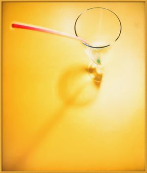 glass with a straw is on a yellow background