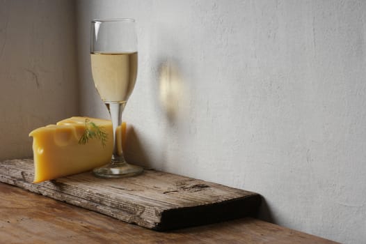 A glass of wine and cheese on the background wall