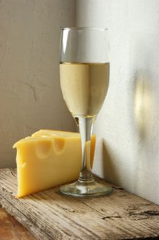 A glass of wine and cheese on the background wall