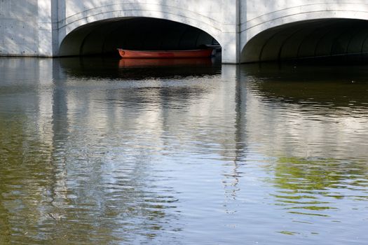 A canoe coming through a low bridge opening.  Speed River, Guelph, Ontario, Canada