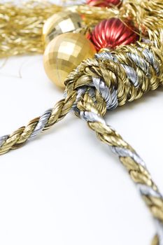 Noose made out of christmas rope, with baubles in the background, isolated on white.