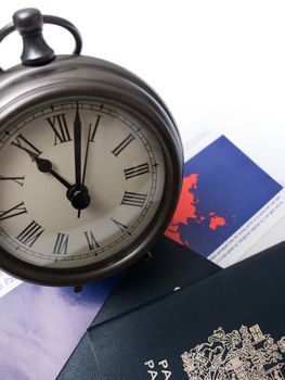 Travel documents under a clock, isolated on white.