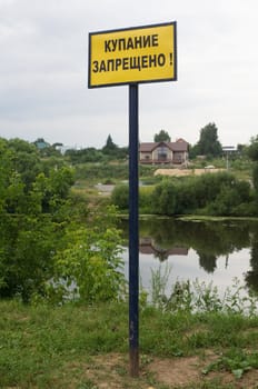 "NO SWIMMING" sign on the shore of the Pakhra river in Podol'sk, Moscow region, Russia
