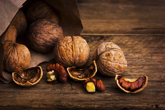 Walnuts in paper bags on the background of an old wooden board