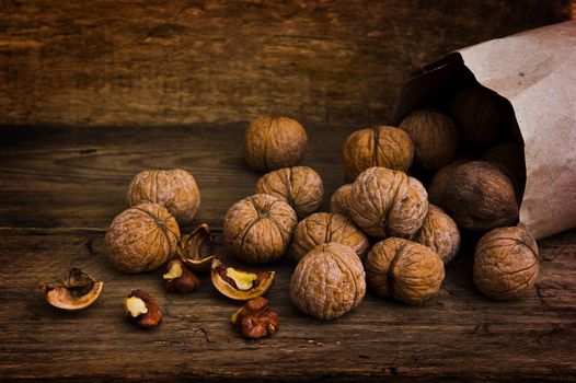 Walnuts in paper bags on the background of an old wooden board