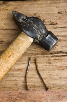 hammer with a rusty nail against a wooden board