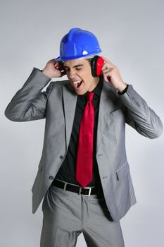 Businessman with blue hardhat and safety headphones for noise
