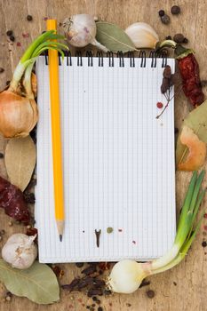 notebook to write recipes on the background of a cutting board with spices