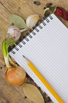 notebook to write recipes on the background of a cutting board with spices