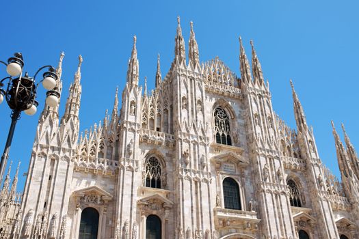 Gothic facade of Milan Cathedral in Piazza Duomo. It is the fourth largest church in the world. The construction started in 1386 and took about five centuries.