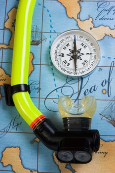  snorkel diving in the background of a map and compass