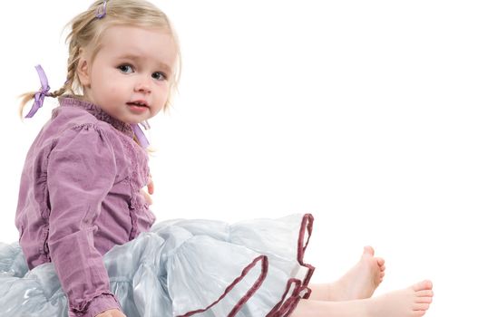 A little girl sitting on the floor in studio