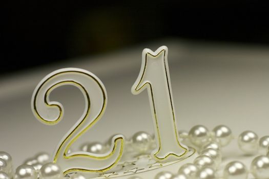 21st birthday sign surrounded by pearls, a celebratory concept