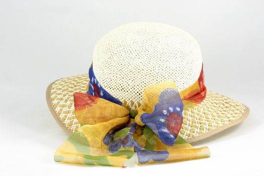 straw hat with a ribbons of printed material around it