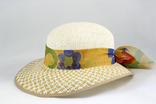 straw hat with a ribbons of printed material around it