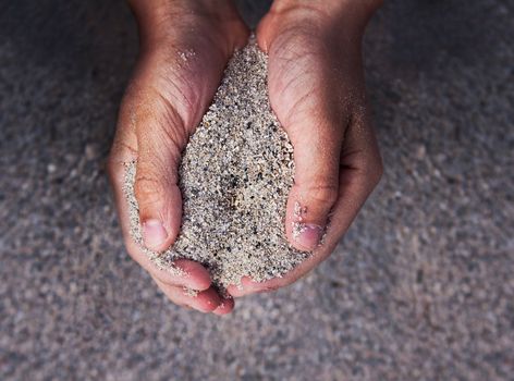 Concept photograph of boy hands holding sand, where any content can be placed in the center of the sand