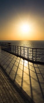 Photograph of a ship rail during sunset