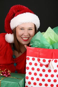Beautiful brunette female with christmas gifts wearing a fluffy hat