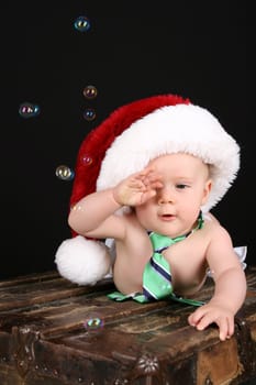 Beautiful christmas baby lying on an antique trunk