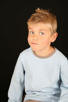 Cute blond boy on a black background