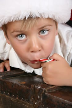 Close up of christmas boy eating a candy cane
