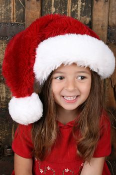Beautiful brunette girl wearing a christmas hat and red dress