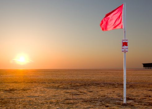 No swimming sign at sunset with no sign of the sea - acreas of sand on Southport beach
