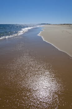 Reflection of the sun on the water over the sand