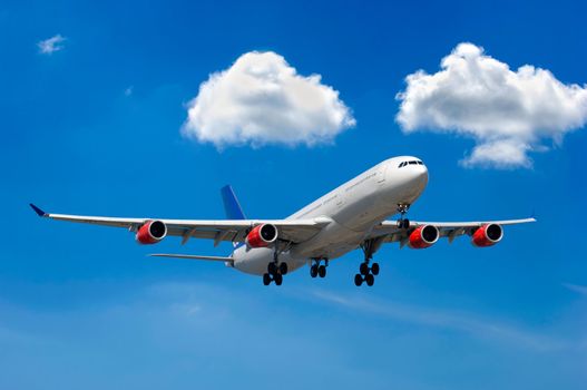Big airliner and two white clouds on a blue sky