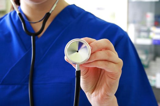 Female doctor holding stethoscope pointed toward camera