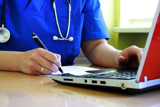 Doctor sitting at his desk with laptop computer