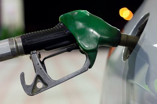 A close-up of a petrol pump while get petrol in a car